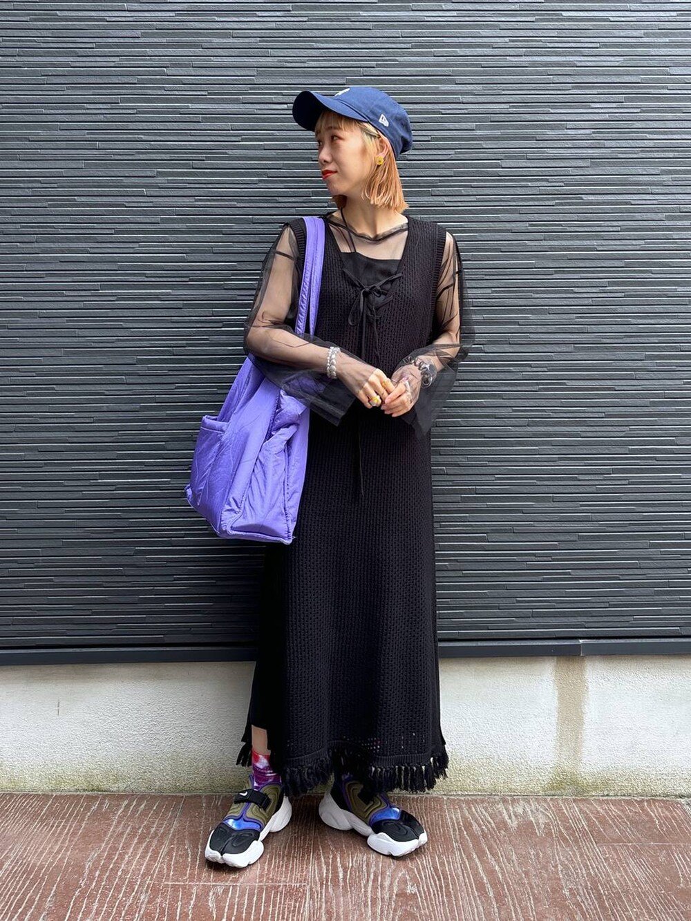 ブラック系のワンピース、パープル系のショルダーバッグ、ブラック系のスカートを着用したレディースの春コーディネートの7枚目の写真