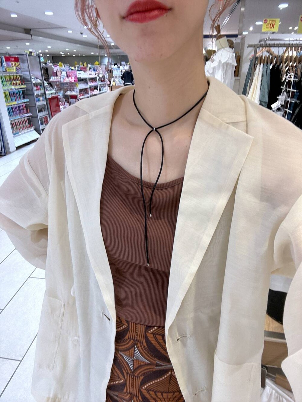 ブラウン系のTシャツ/カットソー、ブラウン系のスカート、パープル系のテーラードジャケットを着用したレディースの夏コーディネートの7枚目の写真