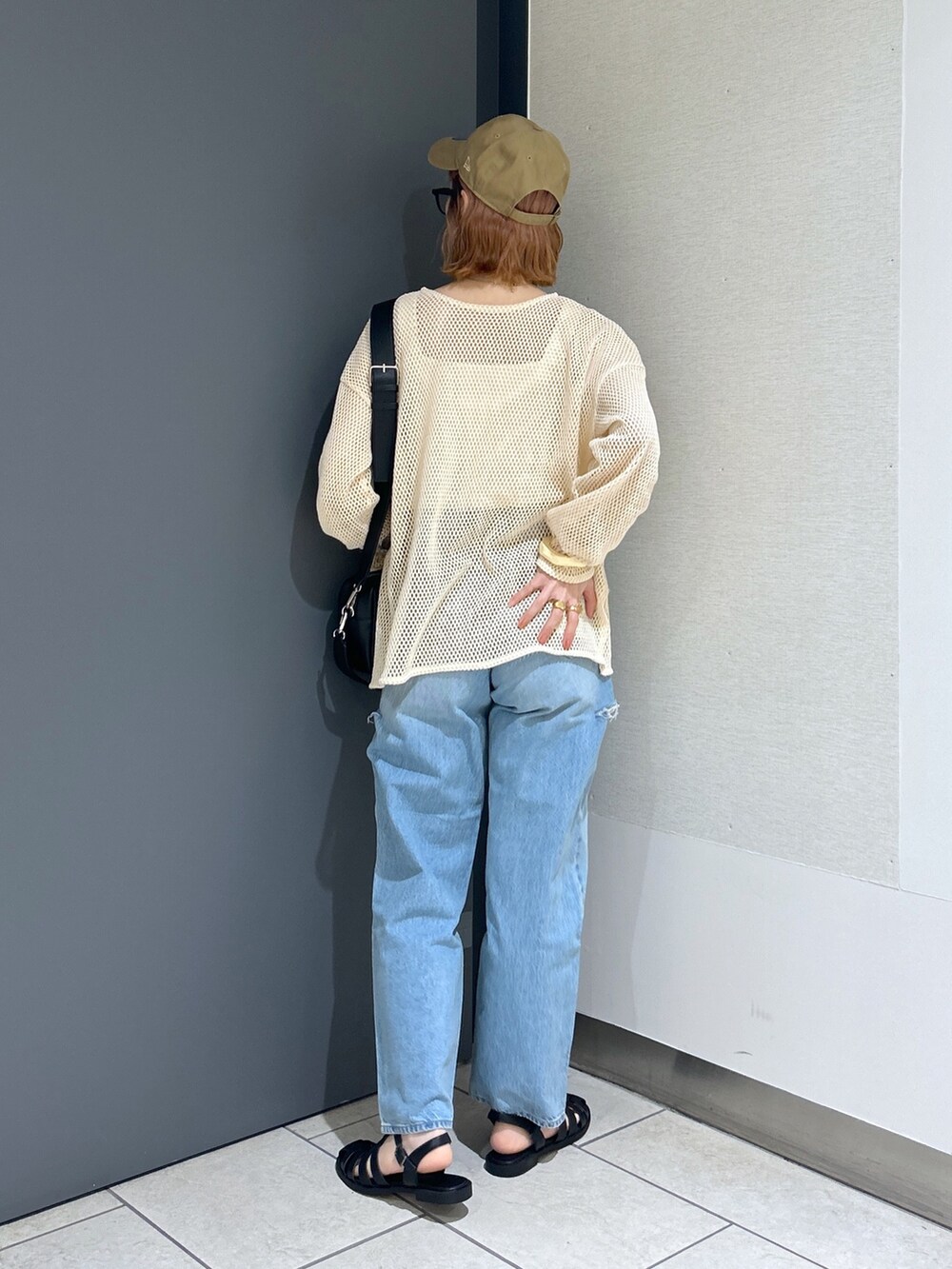 ホワイト系のタンクトップ、ホワイト系のカーディガン/ボレロ、ブラック系のショルダーバッグを着用したレディースの春コーディネートの3枚目の写真