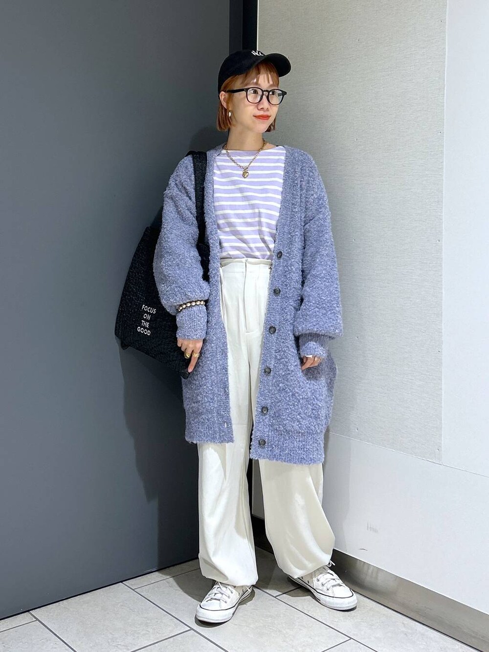 ブラック系のトートバッグ、パープル系のTシャツ/カットソー、パープル系のチュニックを着用したレディースの秋コーディネートの2枚目の写真