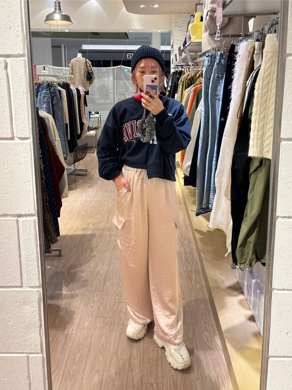 レッド系のニット/セーター、ホワイト系のスニーカー、ピンク系のカーゴパンツを着用したレディースの冬コーディネートの2枚目の写真