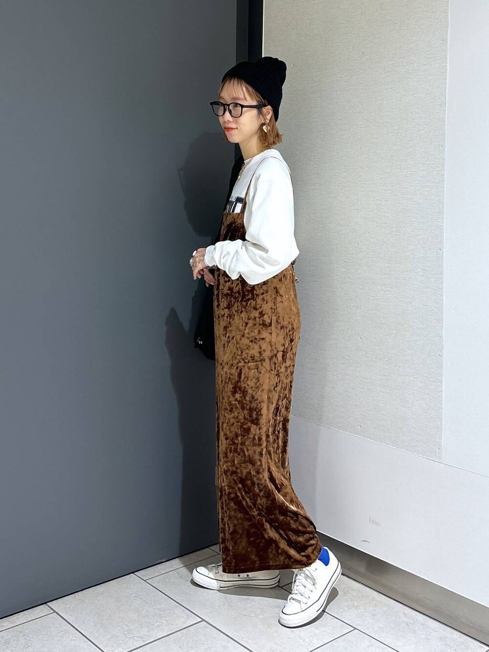 ブラウン系のワンピース、ホワイト系のスウェット、ブラック系のショルダーバッグを着用したレディースの秋コーディネートの2枚目の写真