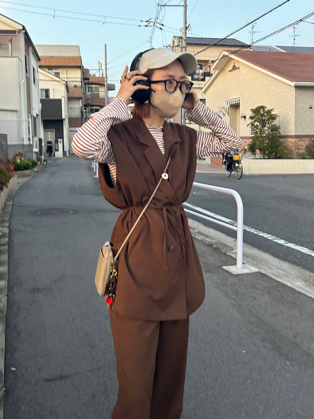 ブラウン系のTシャツ/カットソー、その他のメガネ、ベージュ系のキャップを着用したレディースの秋コーディネートの5枚目の写真