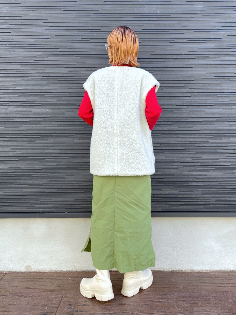 レッド系のニット/セーター、ブラック系のジャケット/アウター、ホワイト系のブーツを着用したレディースの冬コーディネートの7枚目の写真