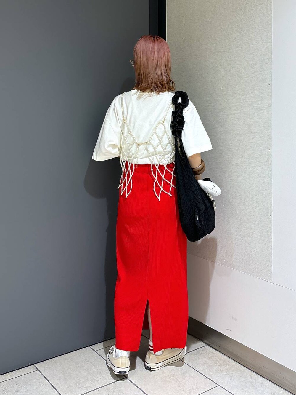 ブラック系のトートバッグ、レッド系のスカート、ホワイト系のベストを着用したレディースの夏コーディネートの4枚目の写真