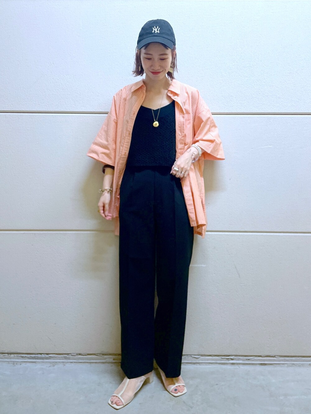 オレンジ系のシャツ/ブラウス、ブラック系のTシャツ/カットソー、ブラック系のベストを着用したレディースの春コーディネートの5枚目の写真