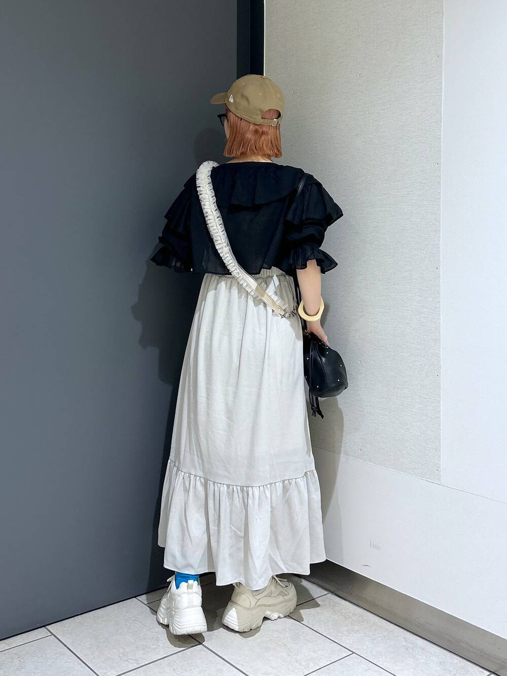 ホワイト系のワンピース、ホワイト系のスニーカー、ブラック系のショルダーバッグを着用したレディースの春コーディネートの4枚目の写真