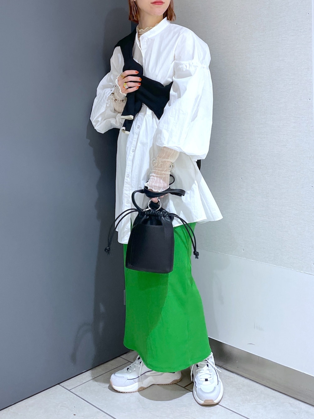 ホワイト系のスニーカー、グリーン系のスカート、ピンク系のバッグを着用したレディースの春コーディネートの2枚目の写真