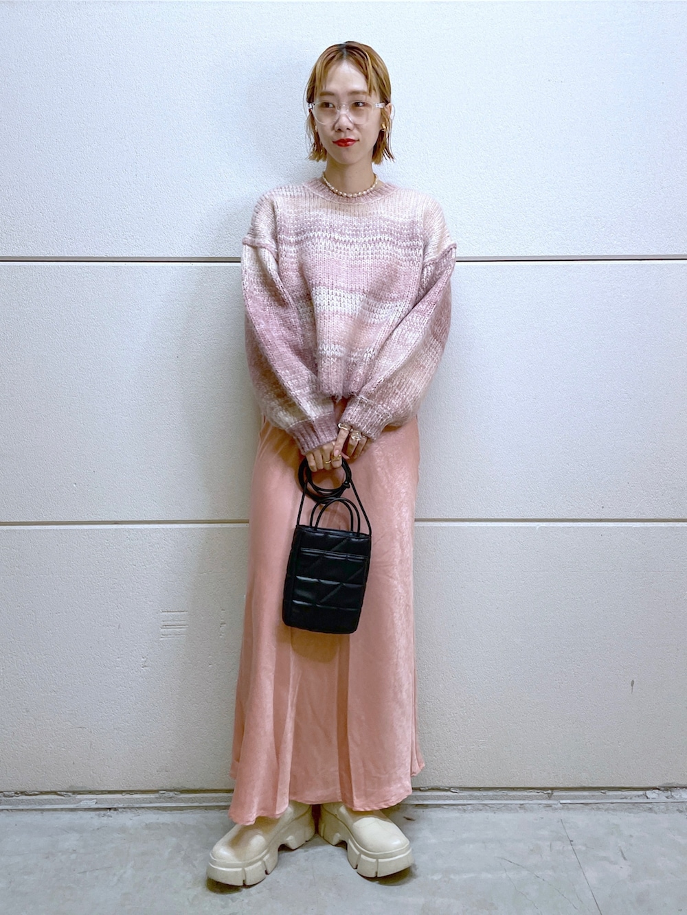 ホワイト系のシューズ、ピンク系のニット/セーター、ピンク系のスカートを着用したレディースの秋コーディネートの3枚目の写真