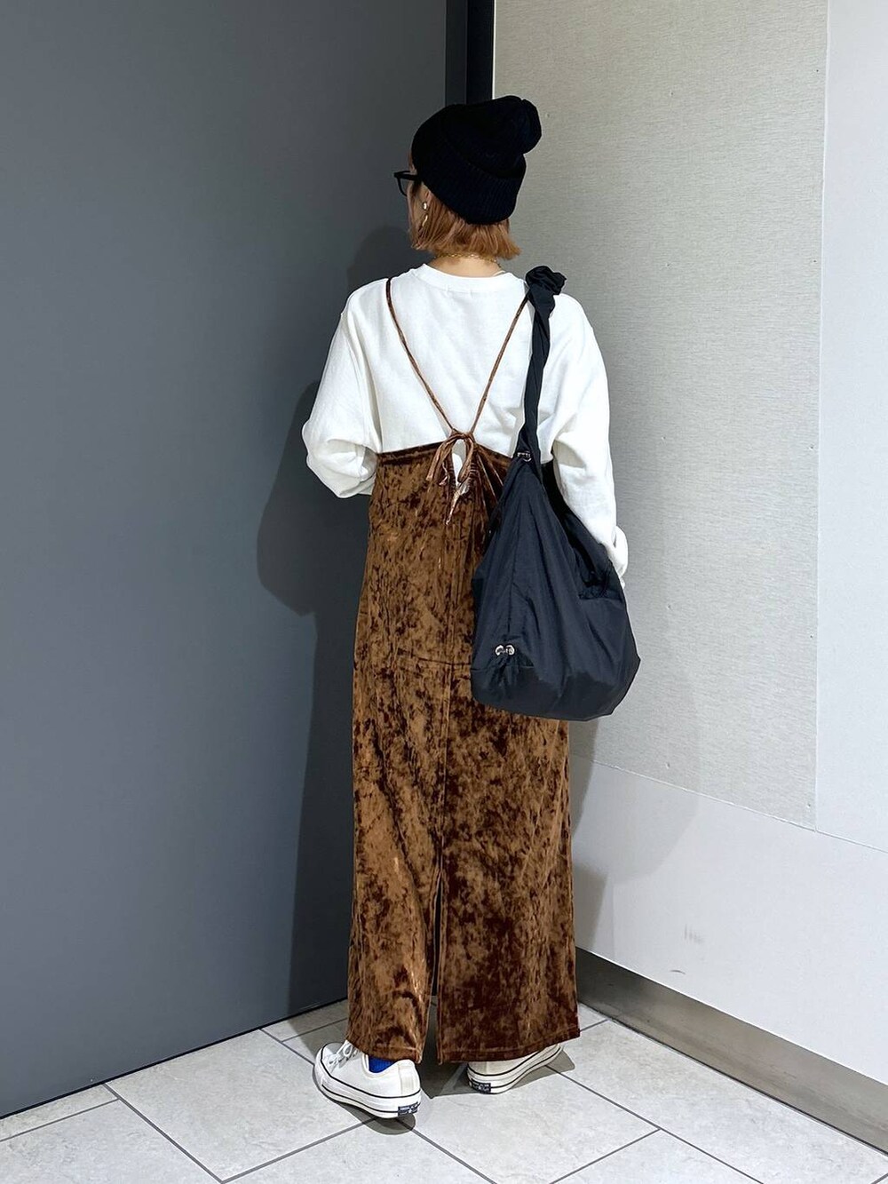 ブラウン系のワンピース、ホワイト系のスウェット、ブラック系のショルダーバッグを着用したレディースの秋コーディネートの3枚目の写真