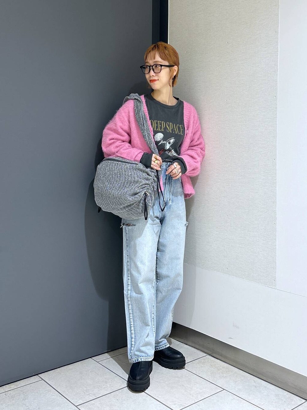 ブルー系のデニムパンツ、シルバー系のショルダーバッグ、ピンク系のカーディガン/ボレロを着用したレディースの冬コーディネートの3枚目の写真