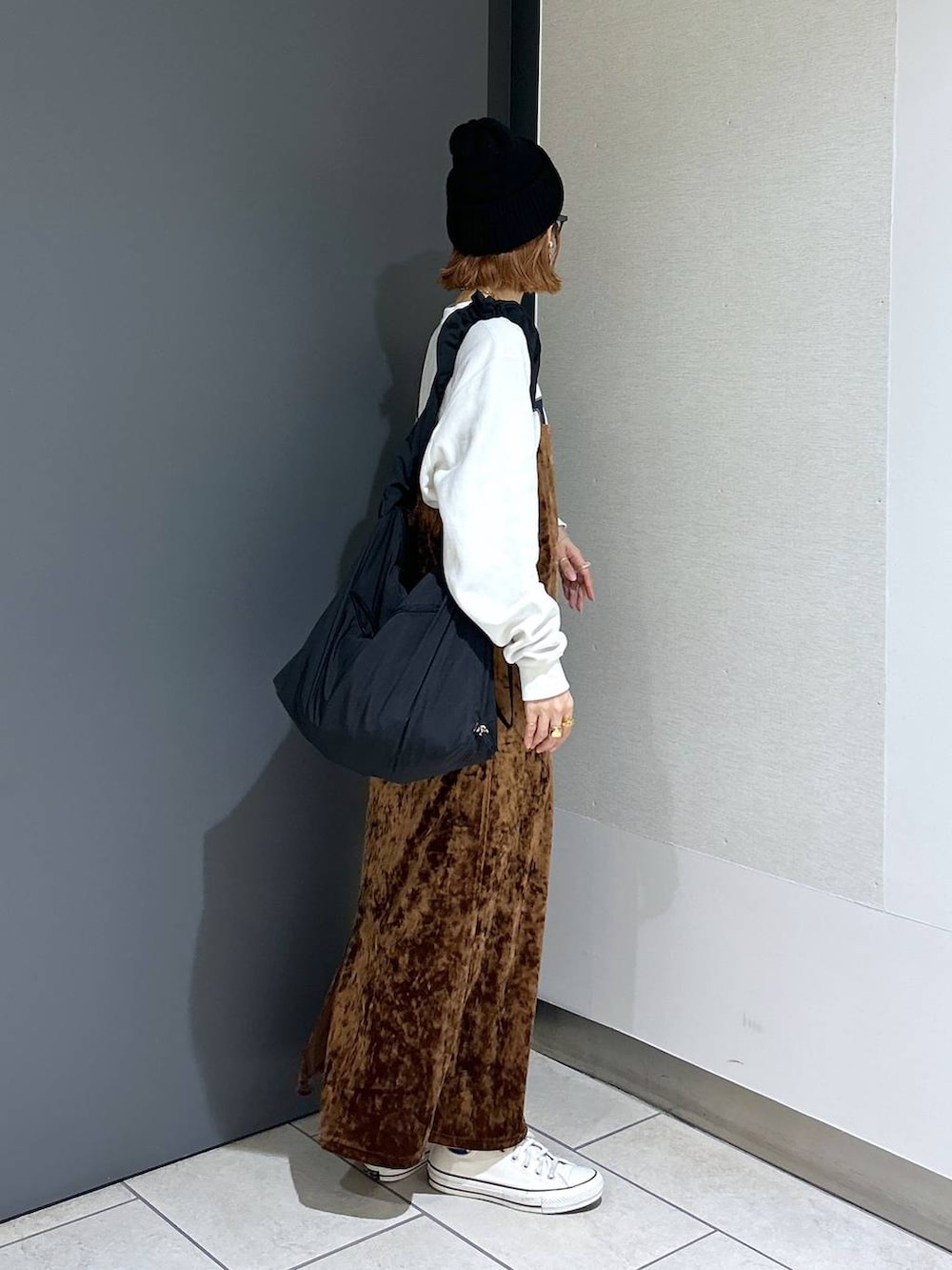 ブラウン系のワンピース、ホワイト系のスウェット、ブラック系のショルダーバッグを着用したレディースの秋コーディネートの4枚目の写真