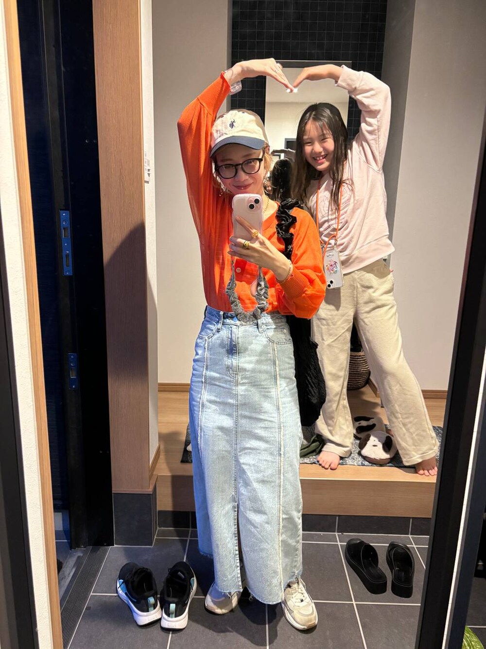 ブラック系のトートバッグ、オレンジ系のカーディガン/ボレロ、ブルー系のスカートを着用したレディースの夏コーディネートの8枚目の写真