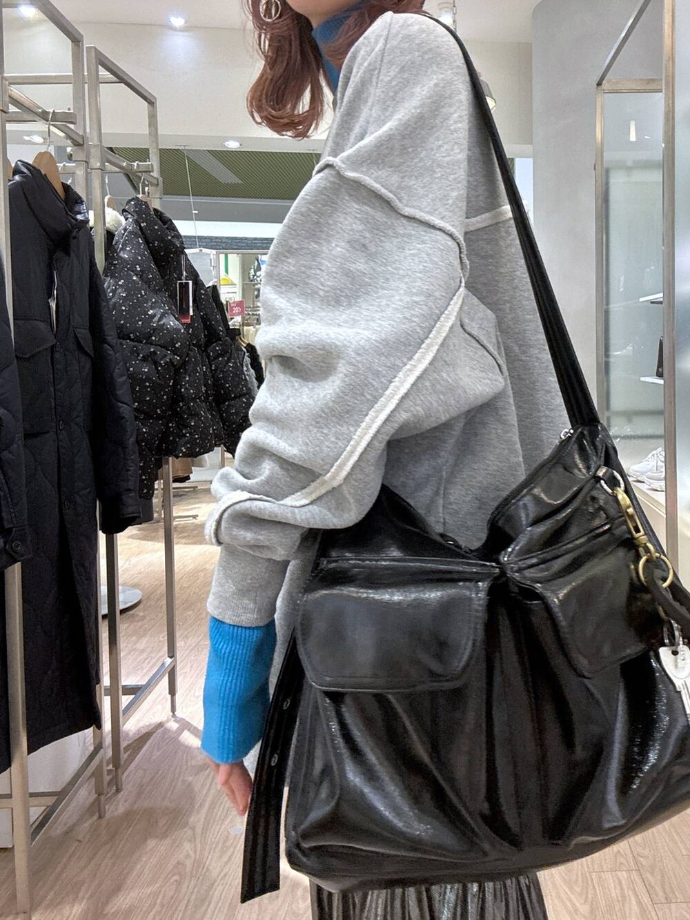 グレー系のスニーカー、ブルー系のニット/セーター、その他のショルダーバッグを着用したレディースの冬コーディネートの5枚目の写真