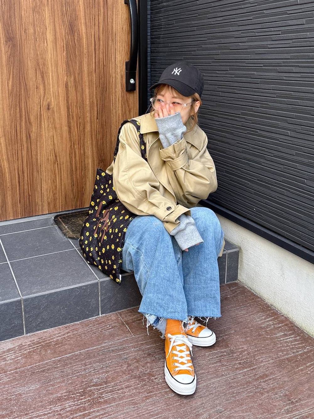 ブラウン系のトレンチコート、ブルー系のデニムパンツ、その他のネックレスを着用したレディースの春コーディネートの9枚目の写真