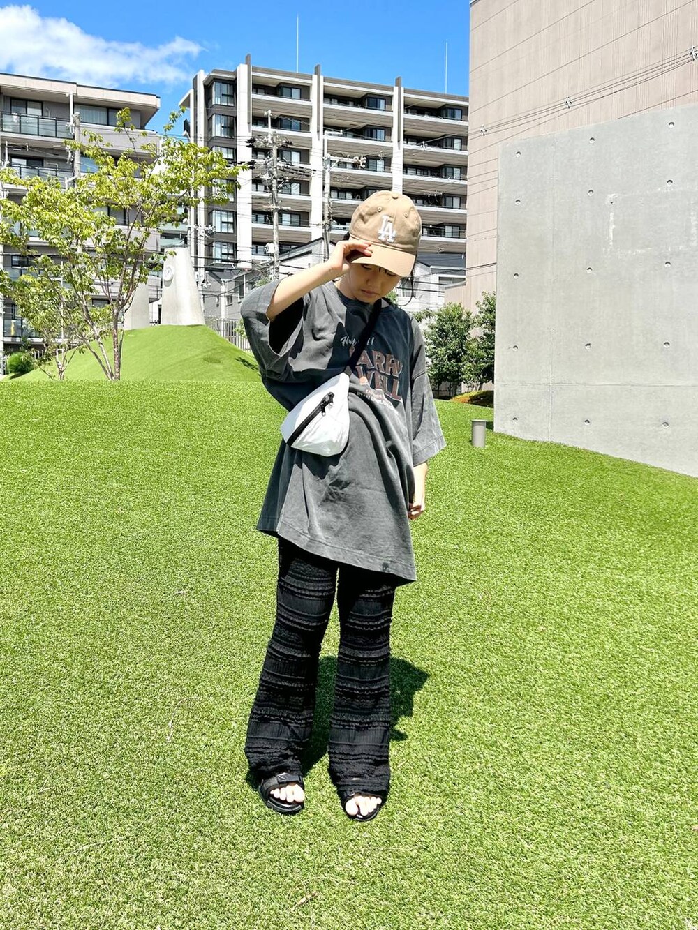 ホワイト系のボディバッグ/ウエストポーチ、ブラック系のその他パンツ、その他のサンダルを着用したレディースの夏コーディネートの6枚目の写真