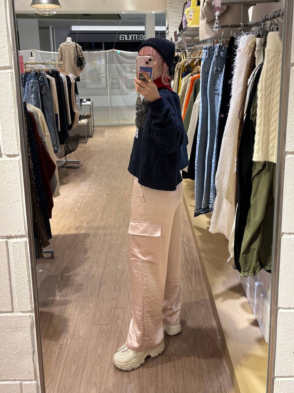 レッド系のニット/セーター、ホワイト系のスニーカー、ピンク系のカーゴパンツを着用したレディースの冬コーディネートの5枚目の写真