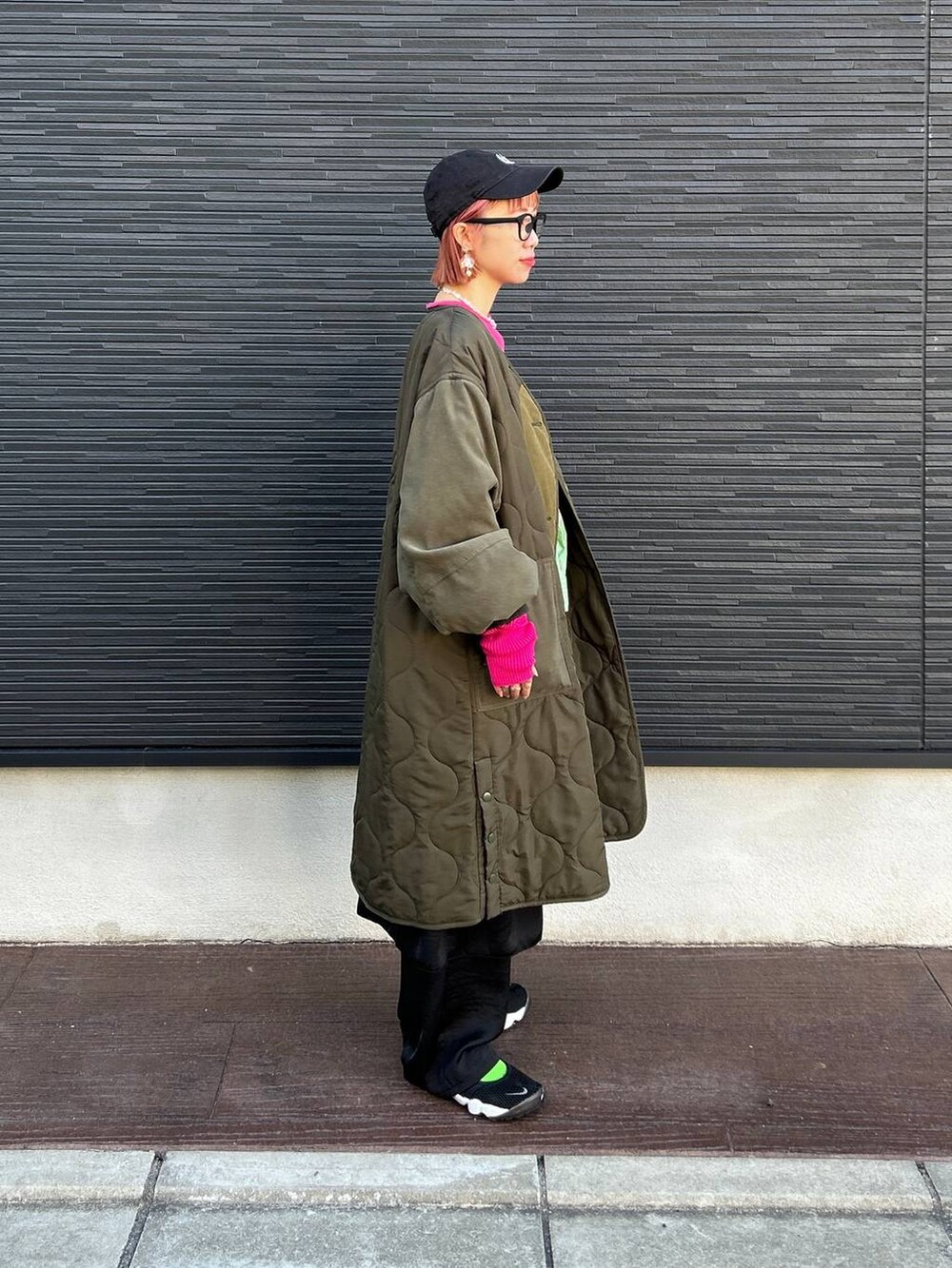 ブルー系のショルダーバッグ、ブラック系のスカート、ブラック系のキャップを着用したレディースの冬コーディネートの3枚目の写真