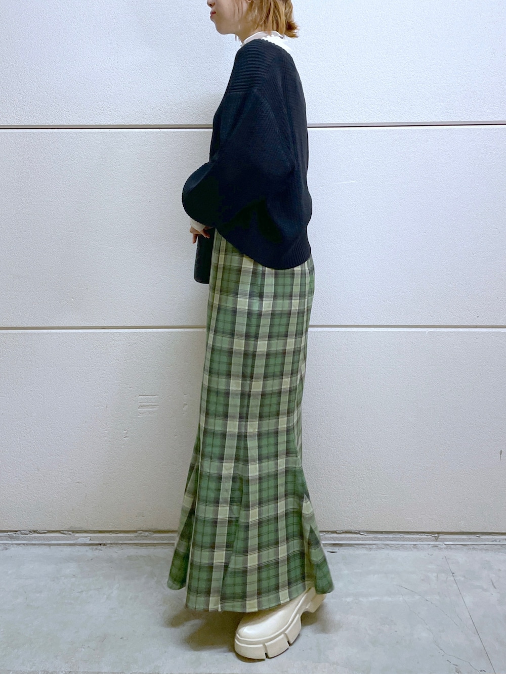 ブラック系のカーディガン/ボレロ、ホワイト系のトップス、グリーン系のスカートを着用したレディースの秋コーディネートの2枚目の写真