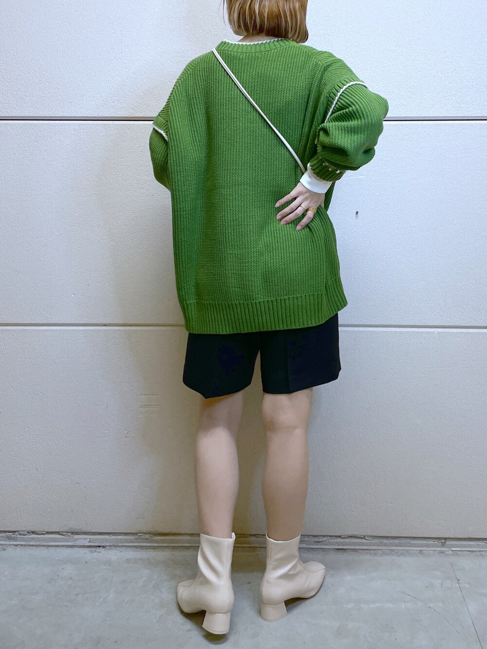 グリーン系のニット/セーター、ブラック系のパンツ、ホワイト系のTシャツ/カットソーを着用したレディースの秋コーディネートの3枚目の写真