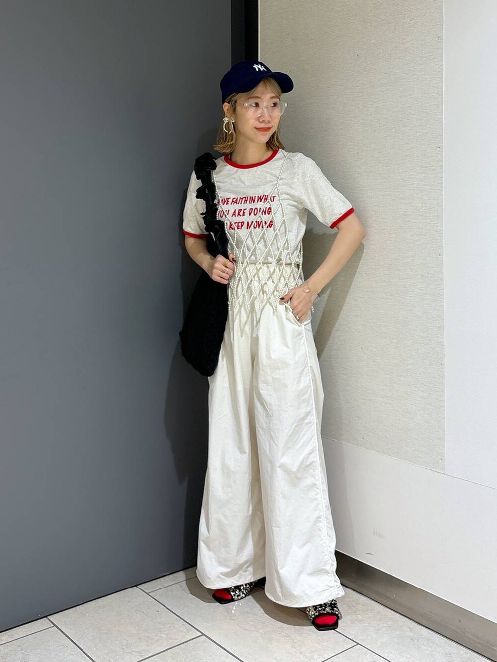 ブラック系のトートバッグ、ホワイト系のTシャツ/カットソー、ホワイト系のベストを着用したレディースの夏コーディネートの6枚目の写真