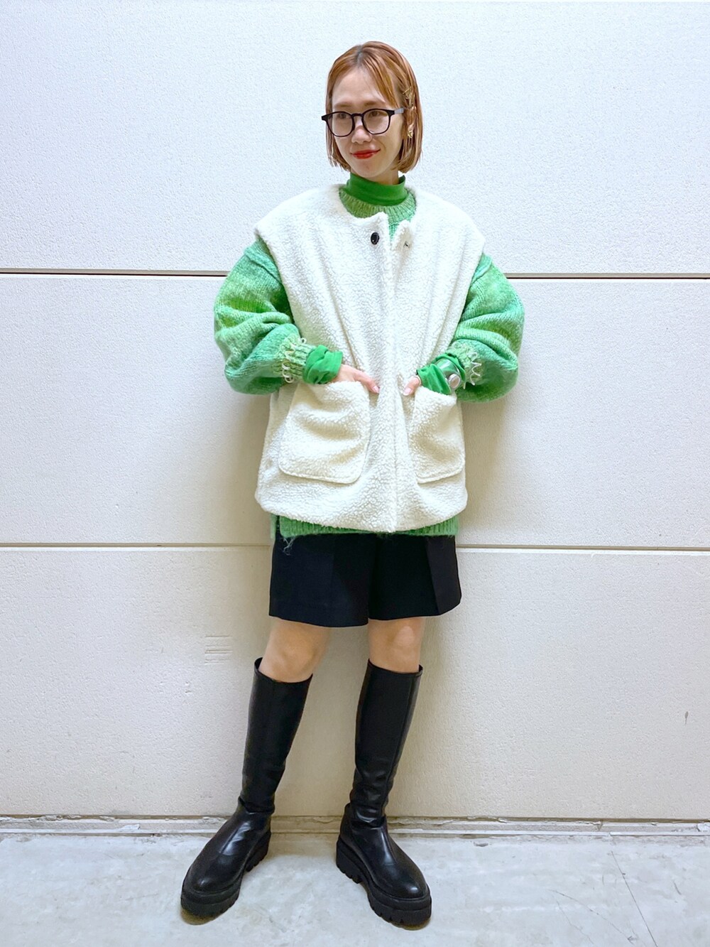 ブラック系のパンツ、グリーン系のニット/セーター、ブラック系のジャケット/アウターを着用したレディースの秋コーディネートの4枚目の写真