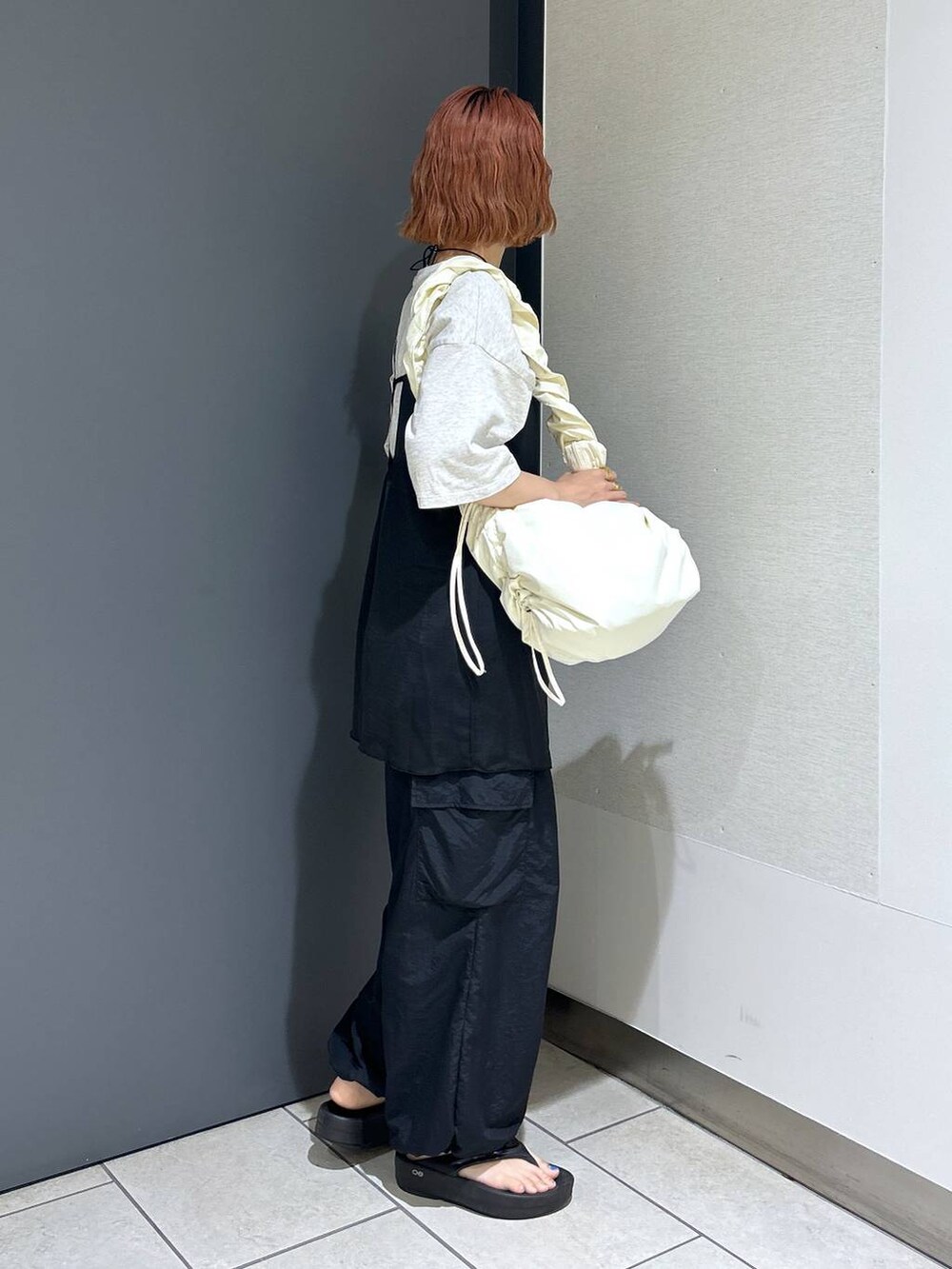 グレー系のTシャツ/カットソー、ブラック系のその他パンツ、ホワイト系のショルダーバッグを着用したレディースの夏コーディネートの4枚目の写真