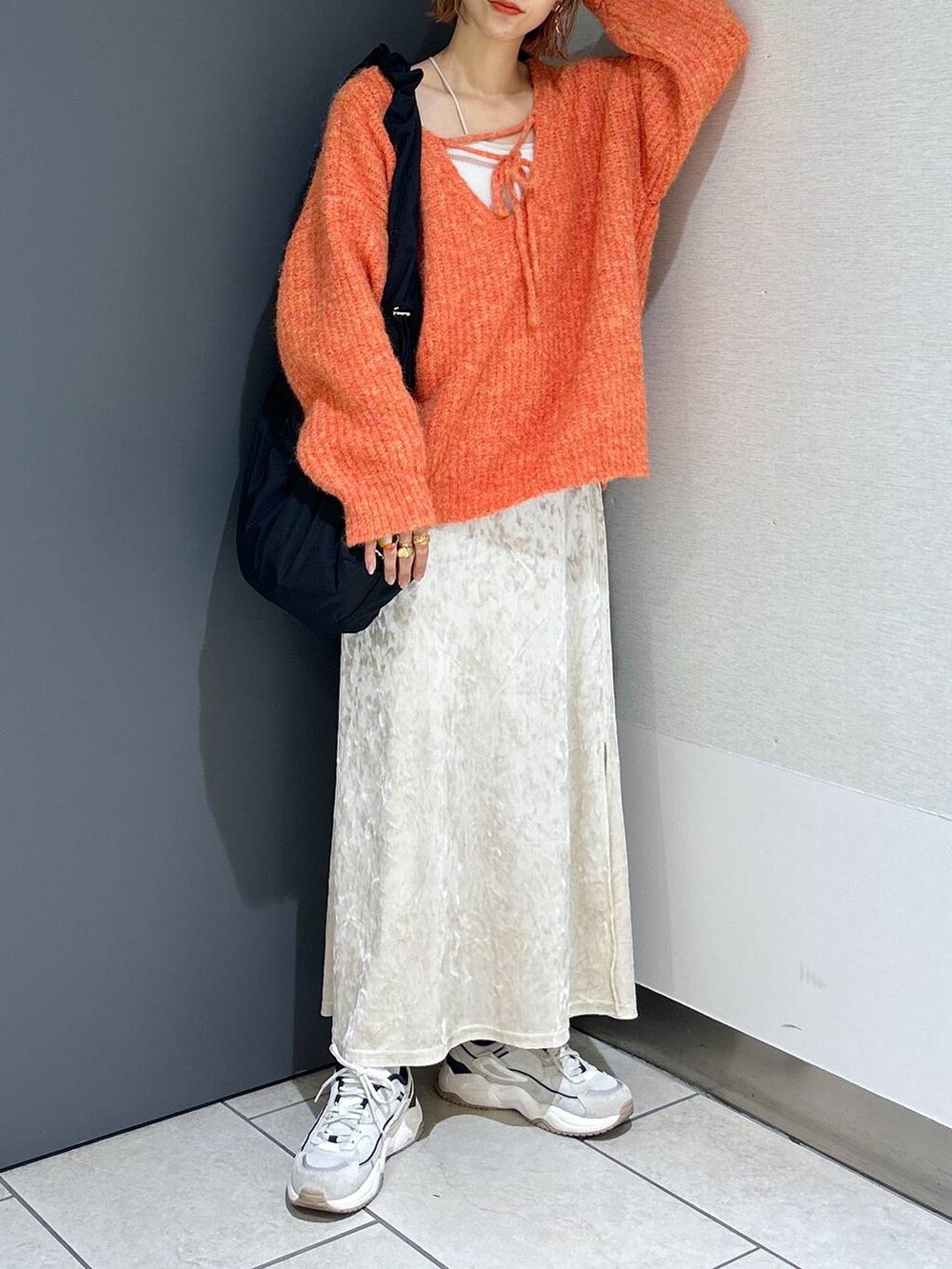 ホワイト系のタンクトップ、オレンジ系のニット/セーター、ホワイト系のスカートを着用したレディースの秋コーディネートの6枚目の写真