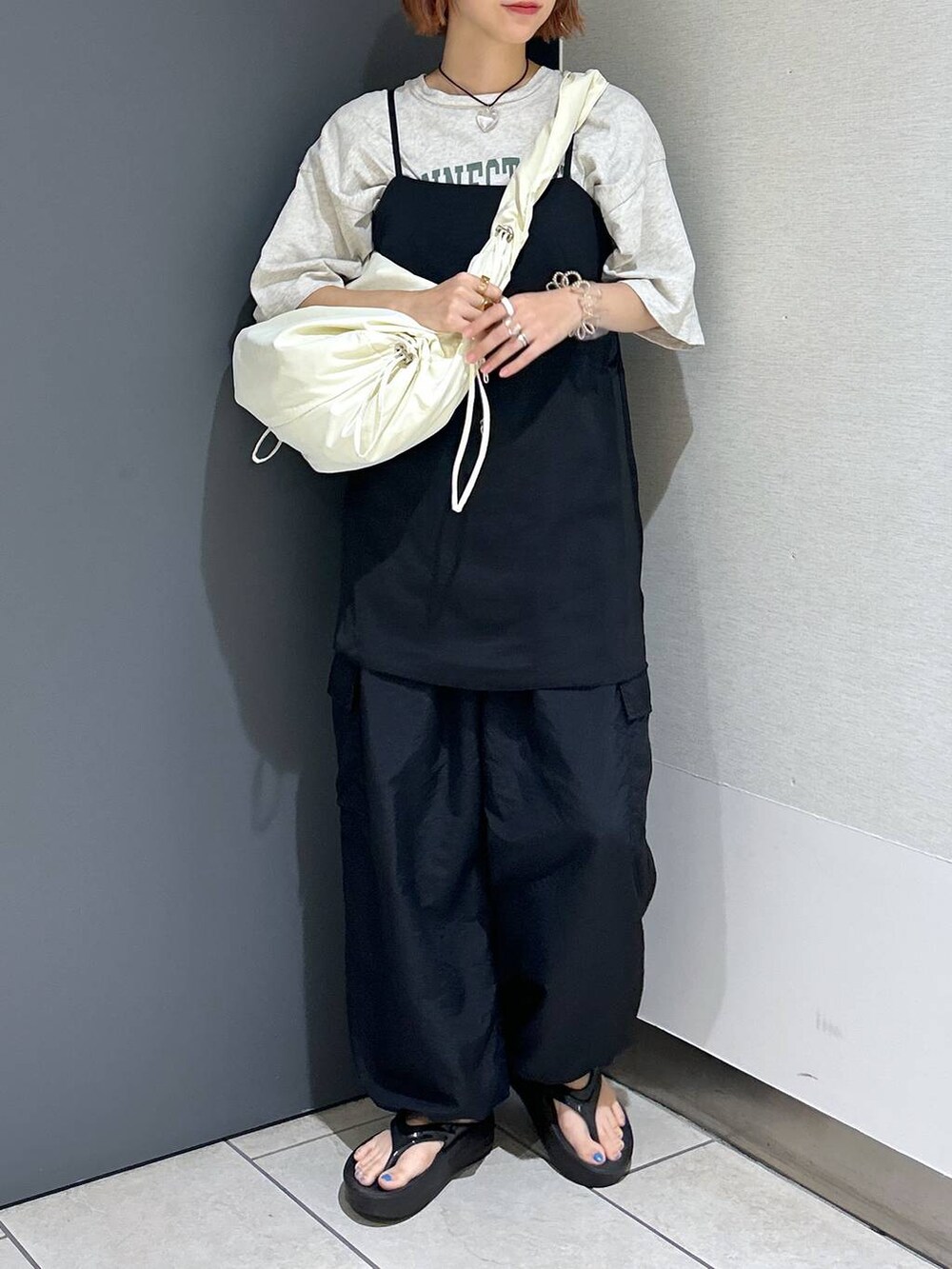 グレー系のTシャツ/カットソー、ブラック系のその他パンツ、ホワイト系のショルダーバッグを着用したレディースの夏コーディネートの7枚目の写真