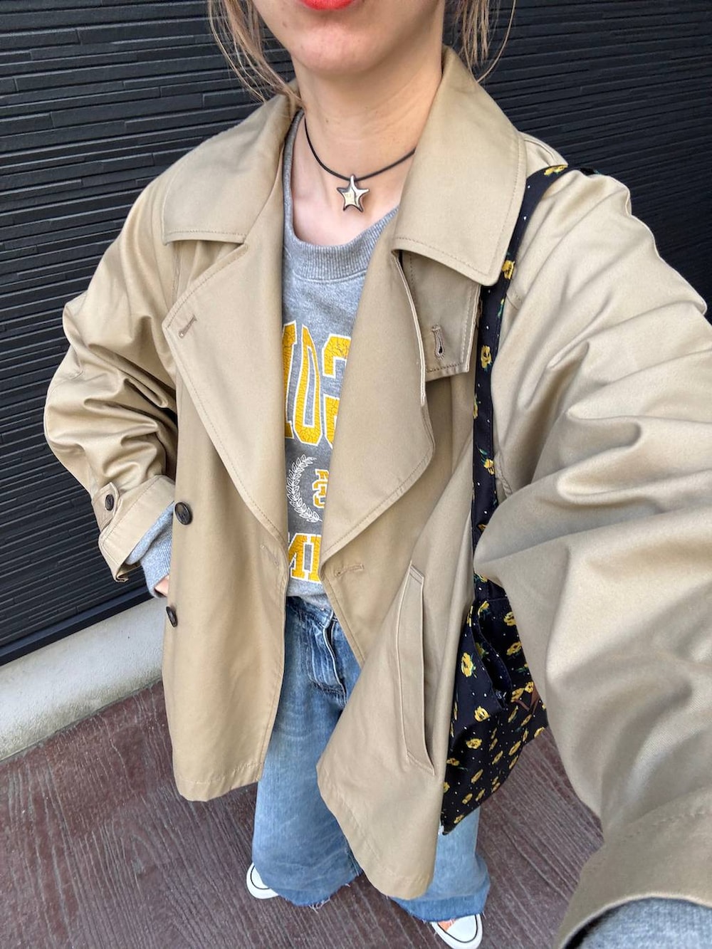 ブラウン系のトレンチコート、ブルー系のデニムパンツ、その他のネックレスを着用したレディースの春コーディネートの3枚目の写真