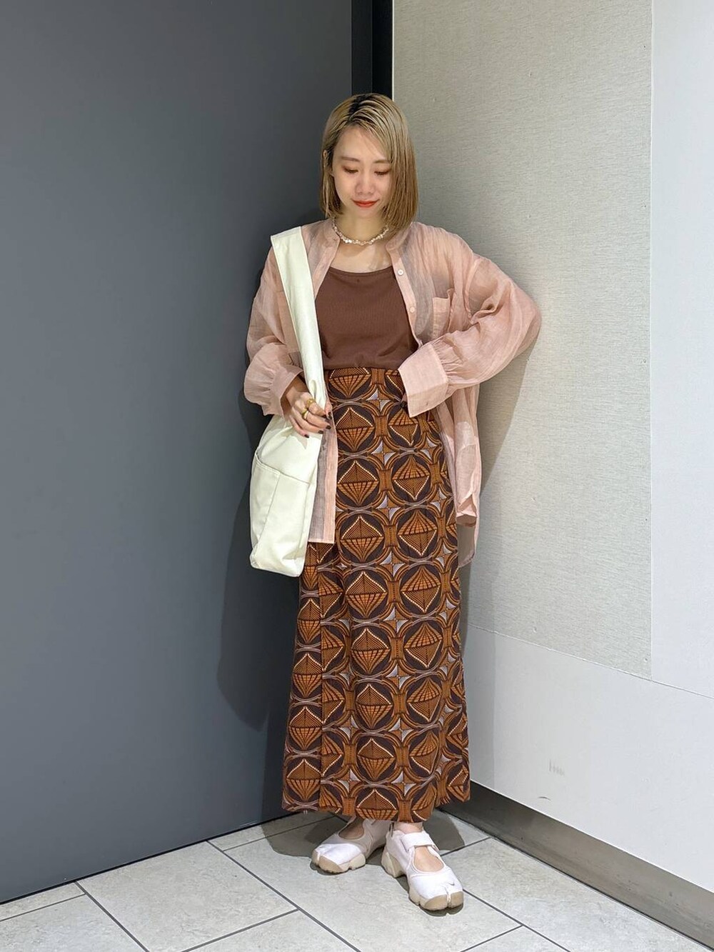 ホワイト系のトートバッグ、ブラウン系のTシャツ/カットソー、ピンク系のシャツ/ブラウスを着用したレディースの夏コーディネートの3枚目の写真