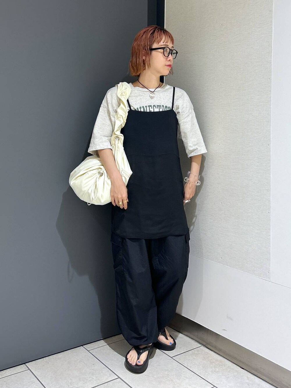 グレー系のTシャツ/カットソー、ブラック系のその他パンツ、ホワイト系のショルダーバッグを着用したレディースの夏コーディネートの9枚目の写真