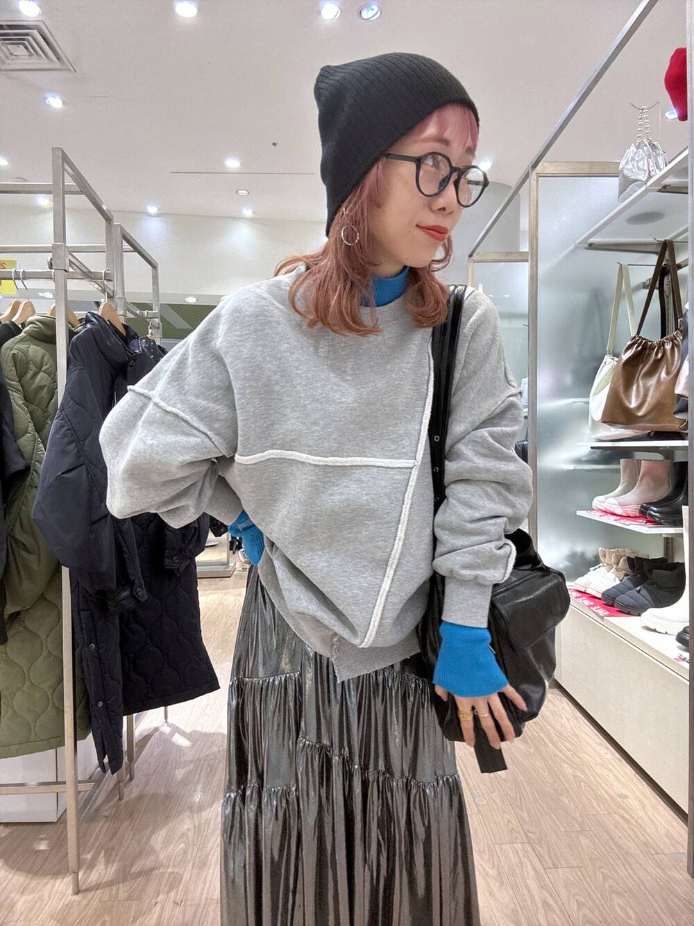 グレー系のスニーカー、ブルー系のニット/セーター、その他のショルダーバッグを着用したレディースの冬コーディネートの2枚目の写真