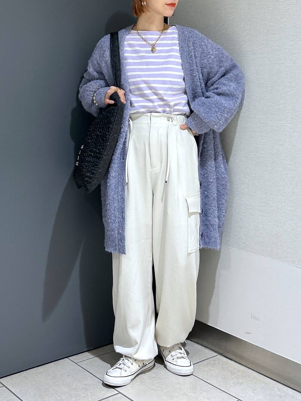 ブラック系のトートバッグ、パープル系のTシャツ/カットソー、パープル系のチュニックを着用したレディースの秋コーディネートの7枚目の写真