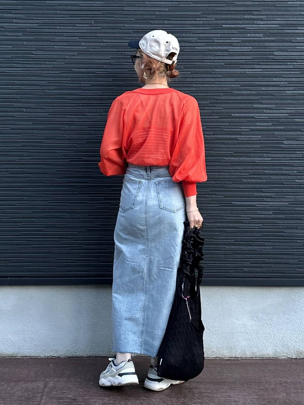 ブラック系のトートバッグ、オレンジ系のカーディガン/ボレロ、ブルー系のスカートを着用したレディースの夏コーディネートの4枚目の写真