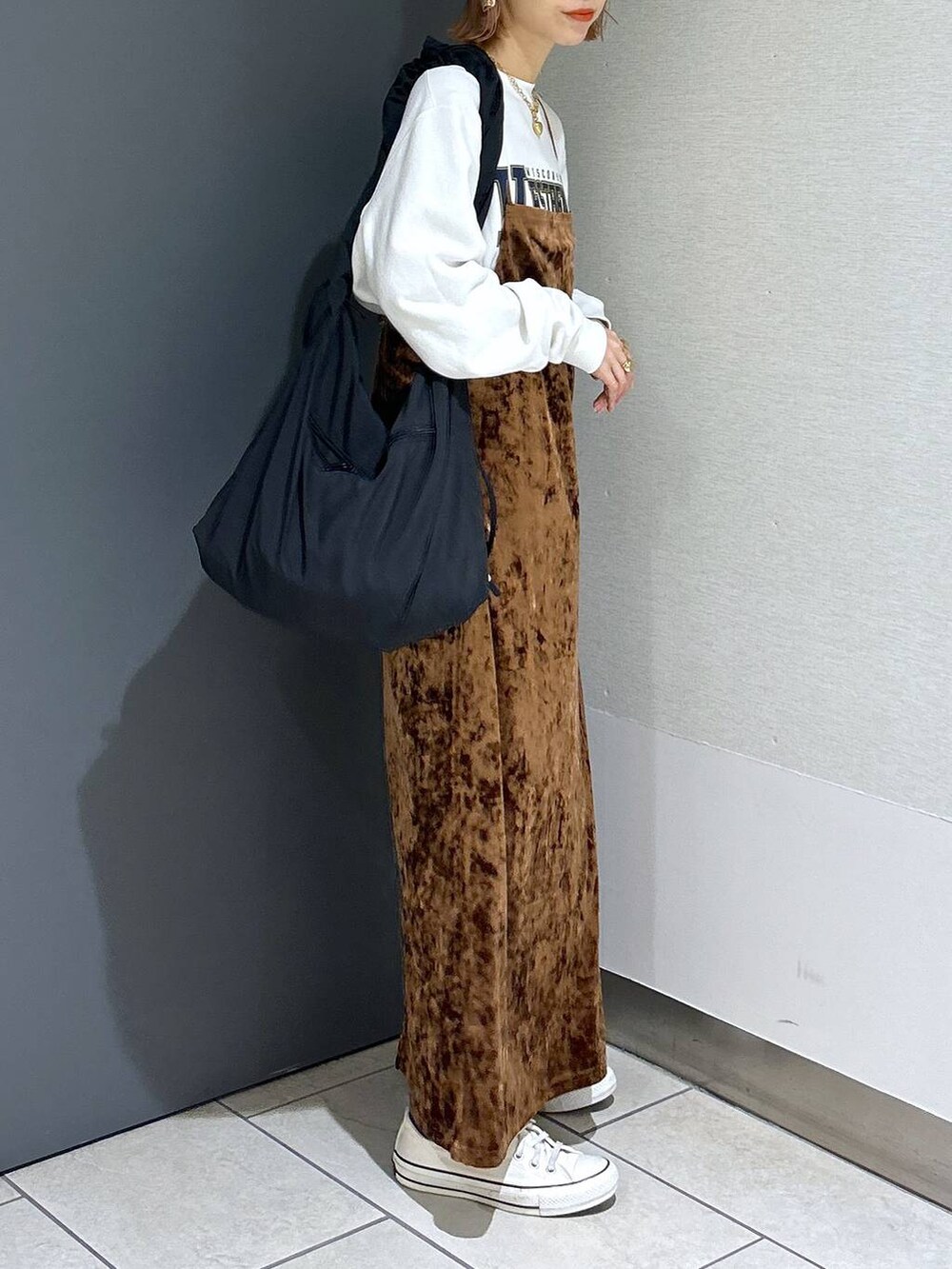 ブラウン系のワンピース、ホワイト系のスウェット、ブラック系のショルダーバッグを着用したレディースの秋コーディネートの5枚目の写真