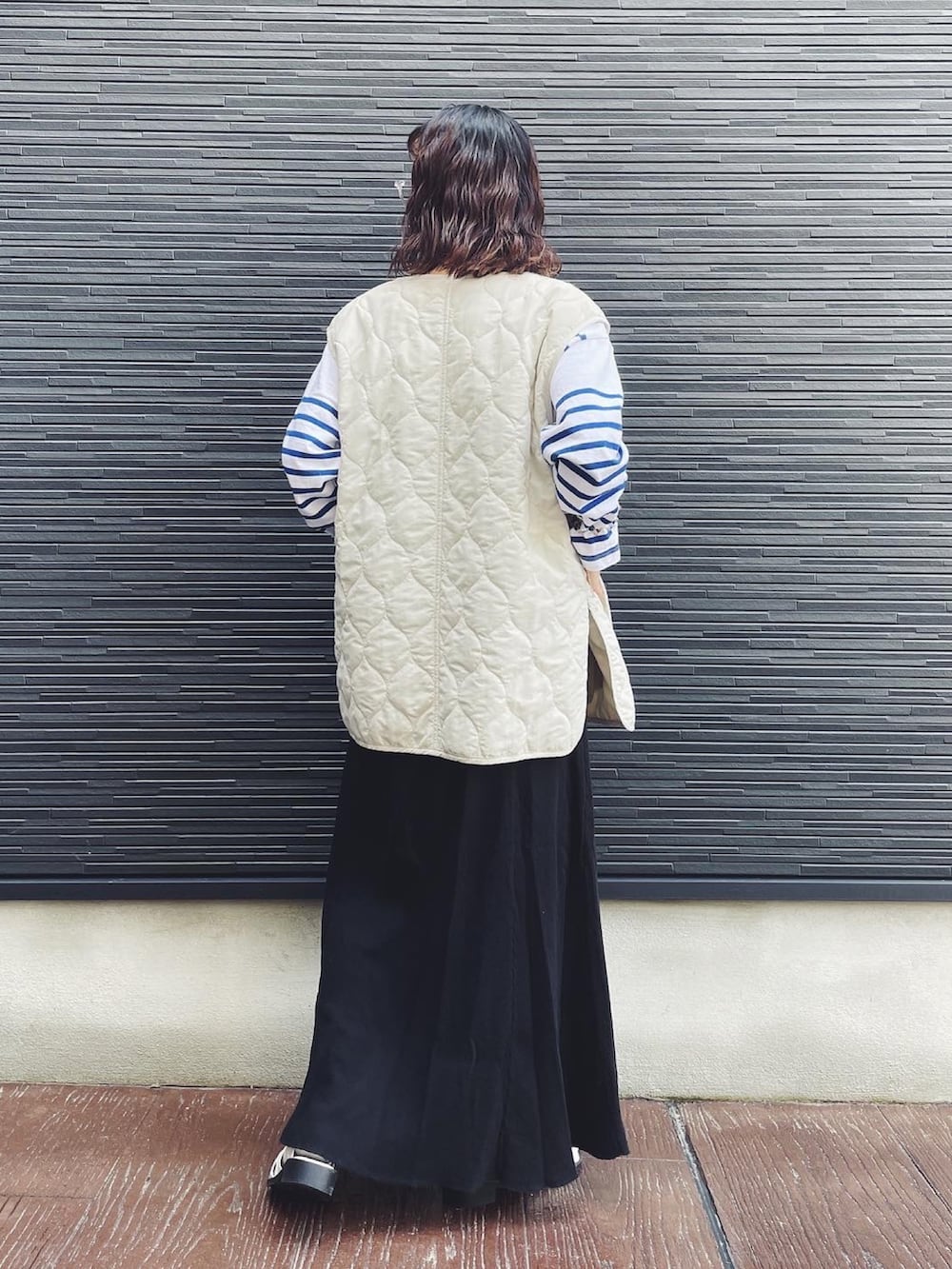 ブルー系のTシャツ/カットソー、ブラック系のスカート、ホワイト系のサンダルを着用したレディースの春コーディネートの3枚目の写真