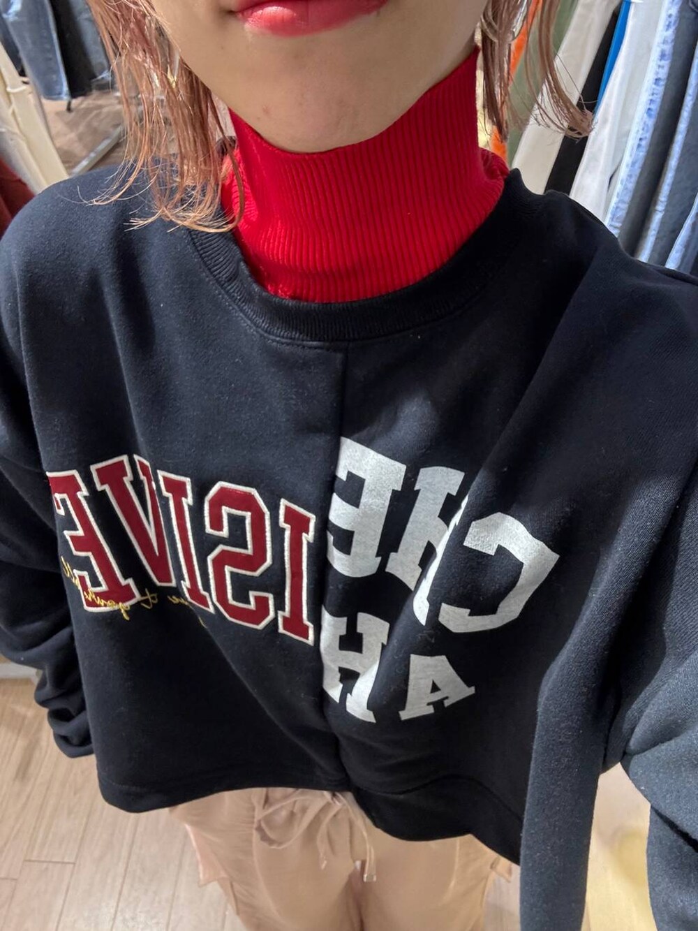 レッド系のニット/セーター、ホワイト系のスニーカー、ピンク系のカーゴパンツを着用したレディースの冬コーディネートの3枚目の写真