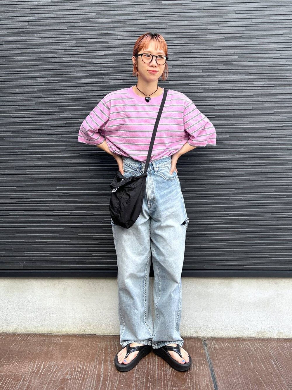 ピンク系のTシャツ/カットソー、ブラック系のショルダーバッグ、ブルー系のデニムパンツを着用したレディースの夏コーディネートの4枚目の写真