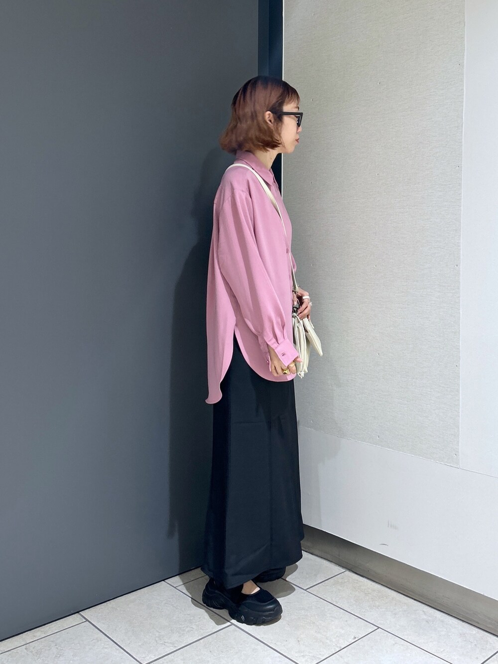 ブラック系のスカート、ピンク系のトップス、ホワイト系のトップスを着用したレディースの春コーディネートの3枚目の写真