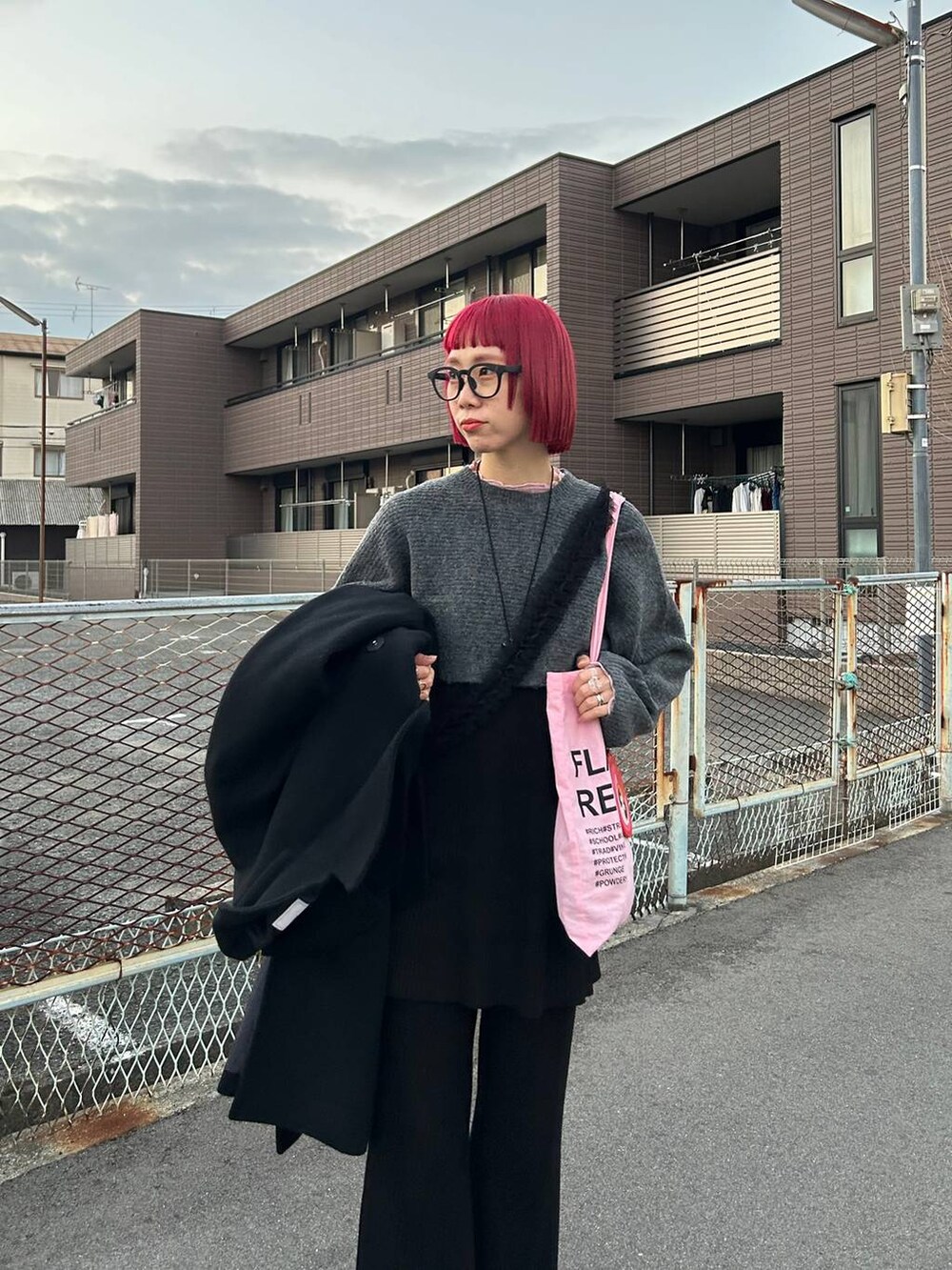 ピンク系のTシャツ/カットソー、グレー系のニット/セーター、ブラック系のスカートを着用したレディースの冬コーディネートの6枚目の写真