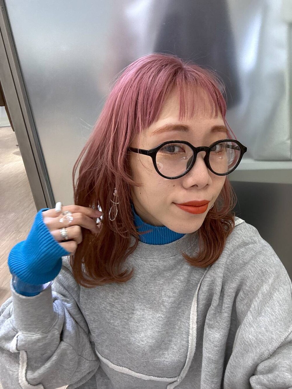 グレー系のスニーカー、ブルー系のニット/セーター、その他のショルダーバッグを着用したレディースの冬コーディネートの10枚目の写真