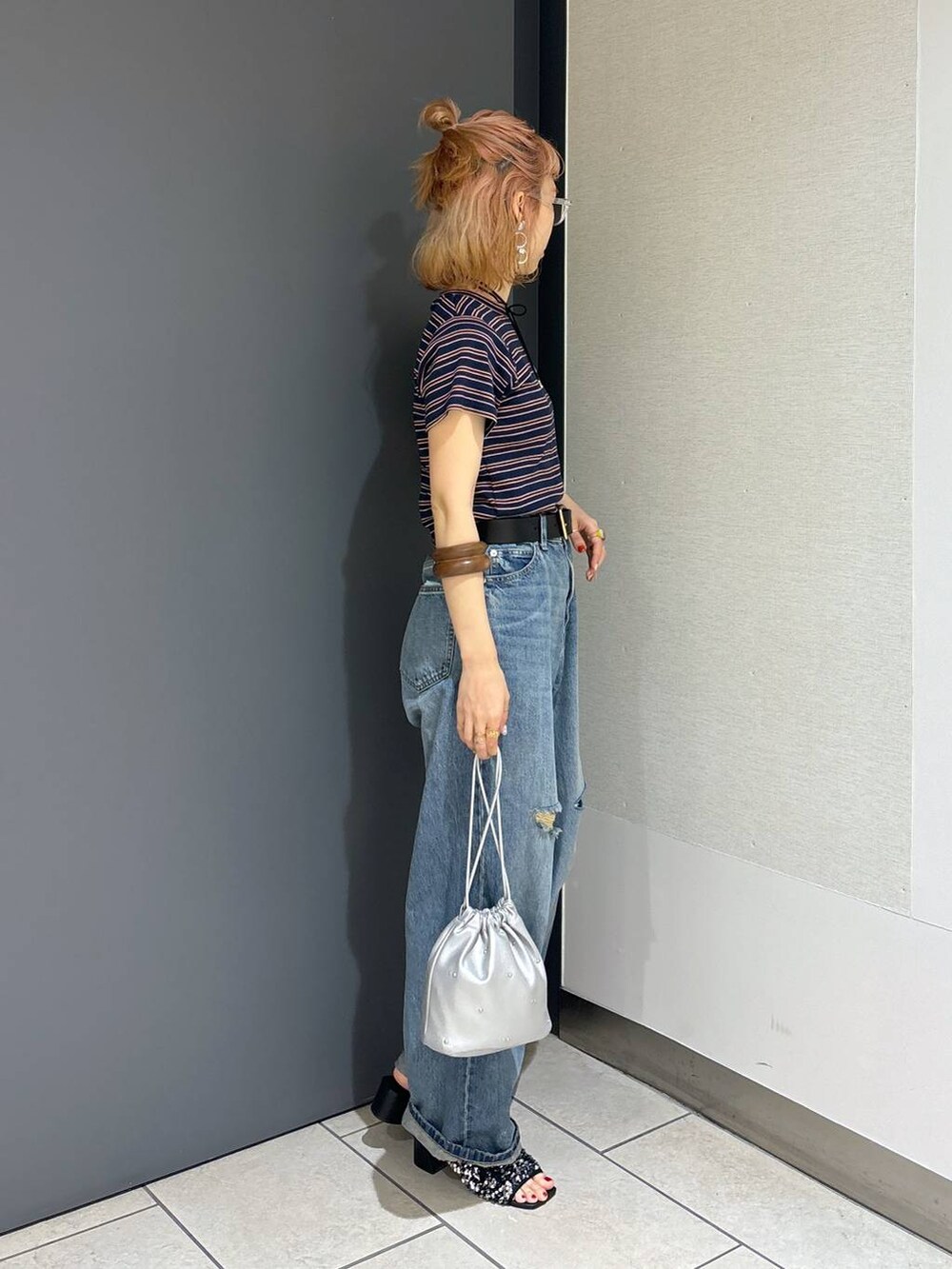 シルバー系のショルダーバッグ、ブルー系のTシャツ/カットソー、ブルー系のデニムパンツを着用したレディースの夏コーディネートの5枚目の写真