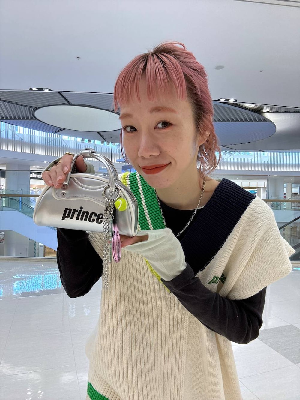 グレー系のTシャツ/カットソー、ホワイト系のサロペット/オーバーオール、ホワイト系のニット/セーターを着用したレディースの冬コーディネートの2枚目の写真