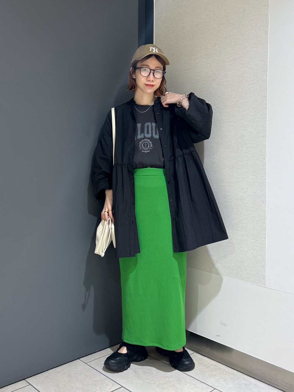 ブラック系のバッグ、グリーン系のスカート、グレー系のTシャツ/カットソーを着用したレディースの春コーディネートの8枚目の写真