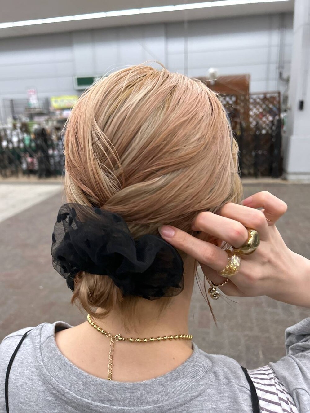 ブラック系のサンダル、ブルー系のデニムパンツ、イエロー系のトートバッグを着用したレディースの春コーディネートの6枚目の写真