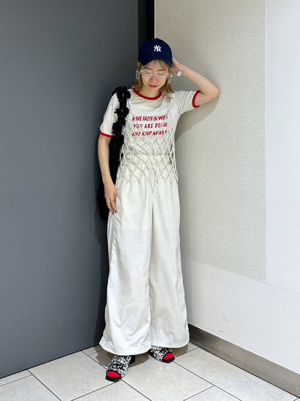 ブラック系のトートバッグ、ホワイト系のTシャツ/カットソー、ホワイト系のベストを着用したレディースの夏コーディネートの2枚目の写真