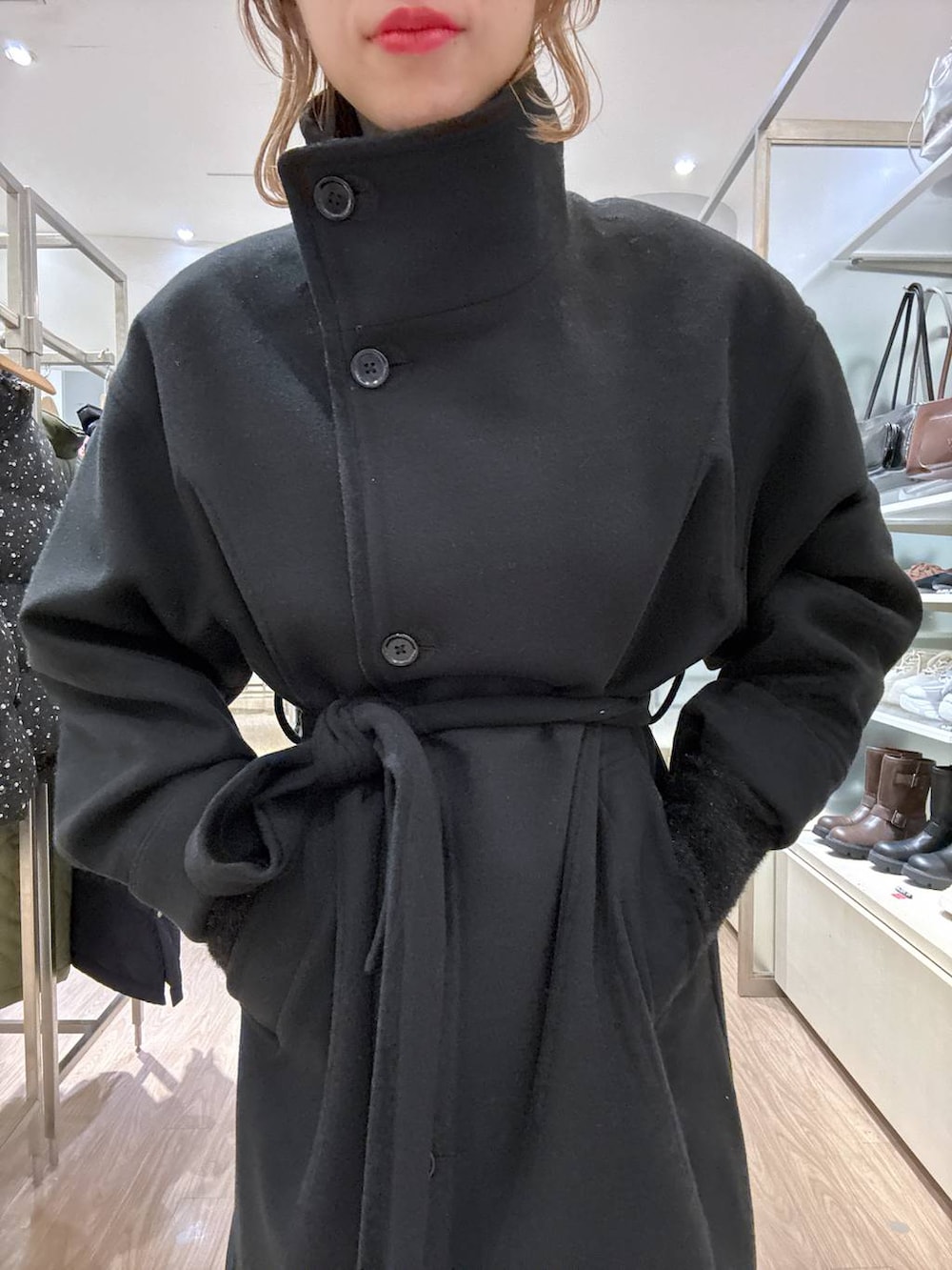 ブラック系のステンカラーコート、ピンク系のカーゴパンツ、ブラック系のニット/セーターを着用したレディースの冬コーディネートの6枚目の写真