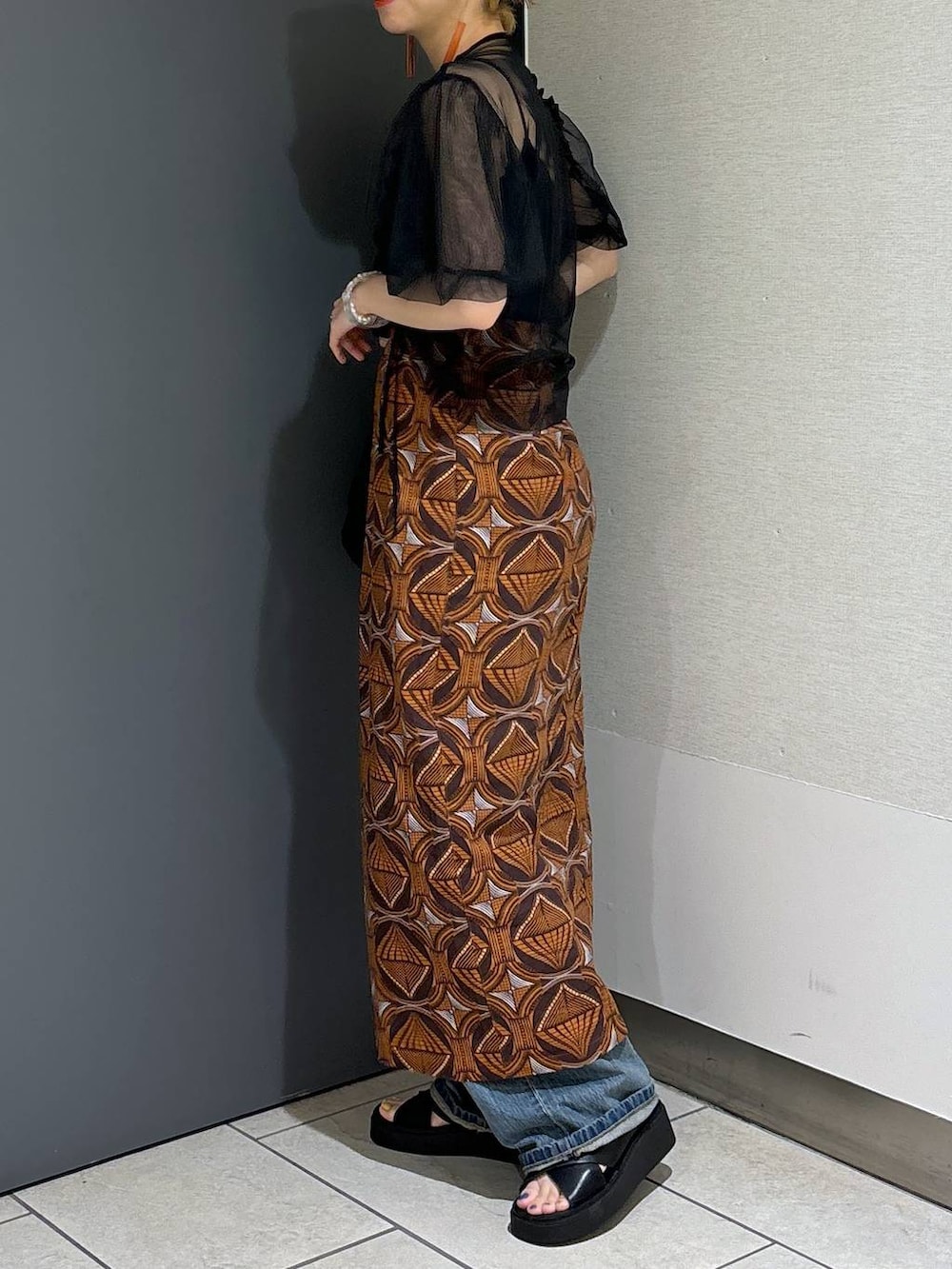 ブラック系のトートバッグ、ブラウン系のスカート、ブラック系のサンダルを着用したレディースの春コーディネートの5枚目の写真