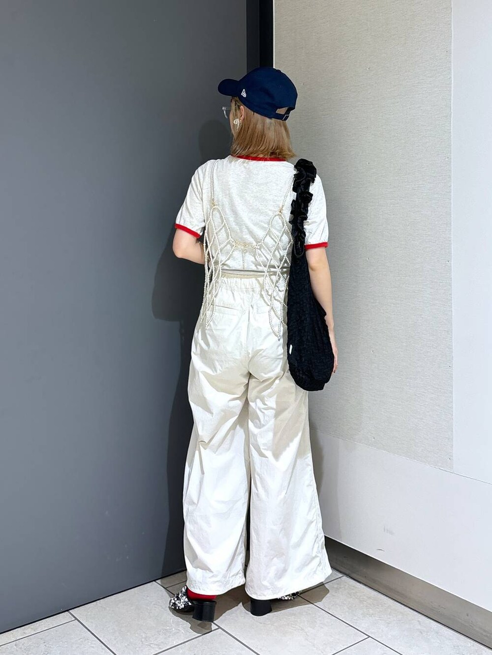ブラック系のトートバッグ、ホワイト系のTシャツ/カットソー、ホワイト系のベストを着用したレディースの夏コーディネートの4枚目の写真